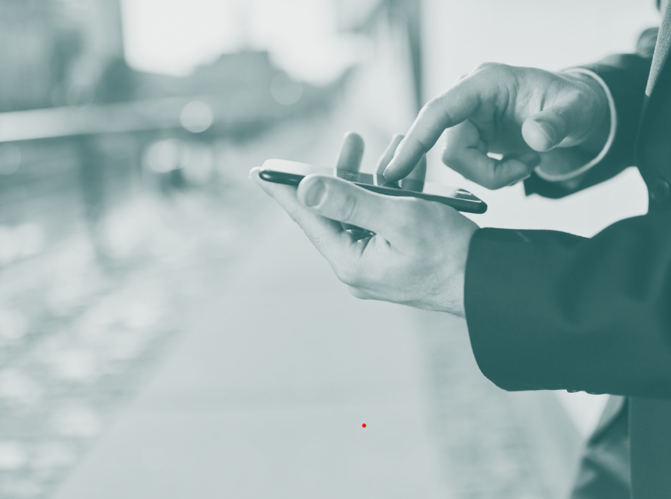 Cropped hands holding smartphone outside business office