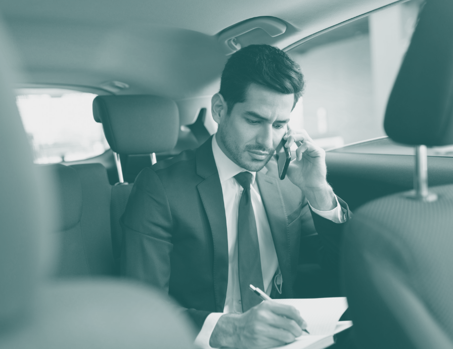 Businessman sitting in car, using smartphone